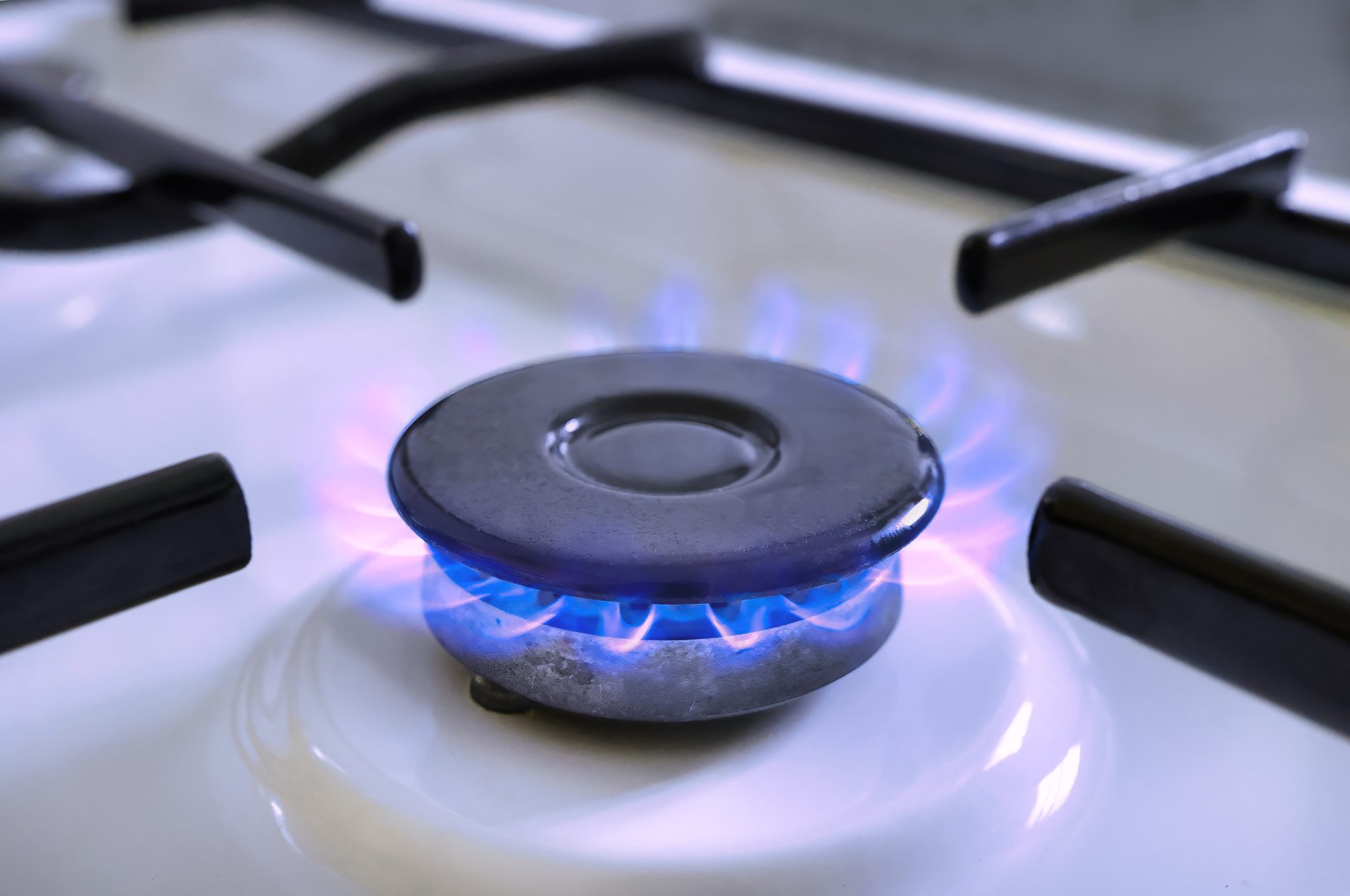 Brûleur de cuisinière allumé avec flamme bleue, image liée au diagnostic gaz pour vente ou location d’un logement.