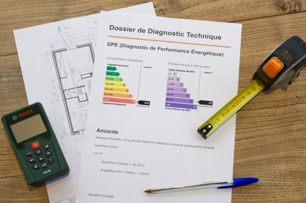 Dossier de Diagnostic de Performance Énergétique posé sur un plan, avec mètre ruban et outil de mesure
