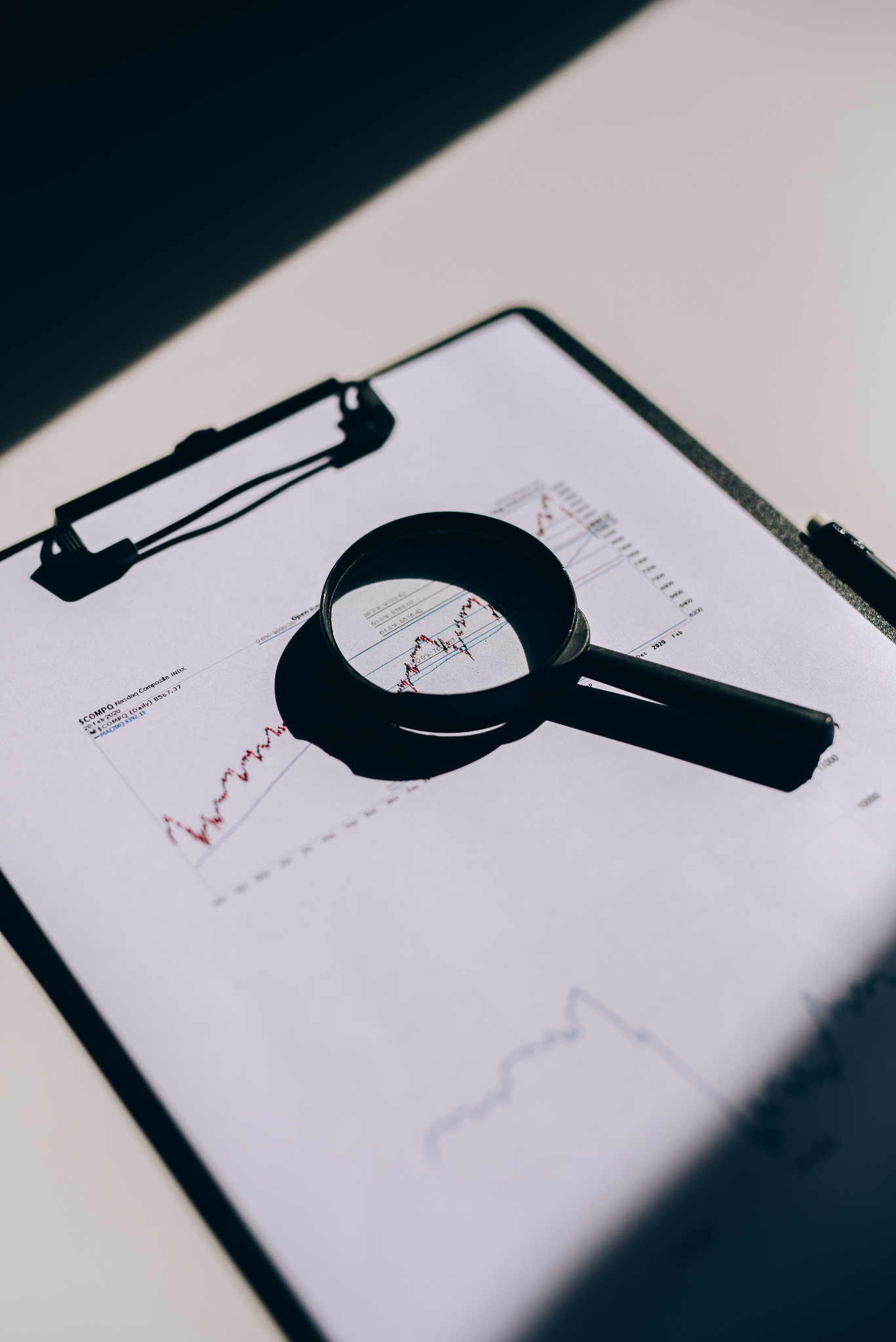 Loupe posée sur un rapport d'analyse illustrant l'examen approfondi réalisé lors d'un audit énergétique obligatoire
