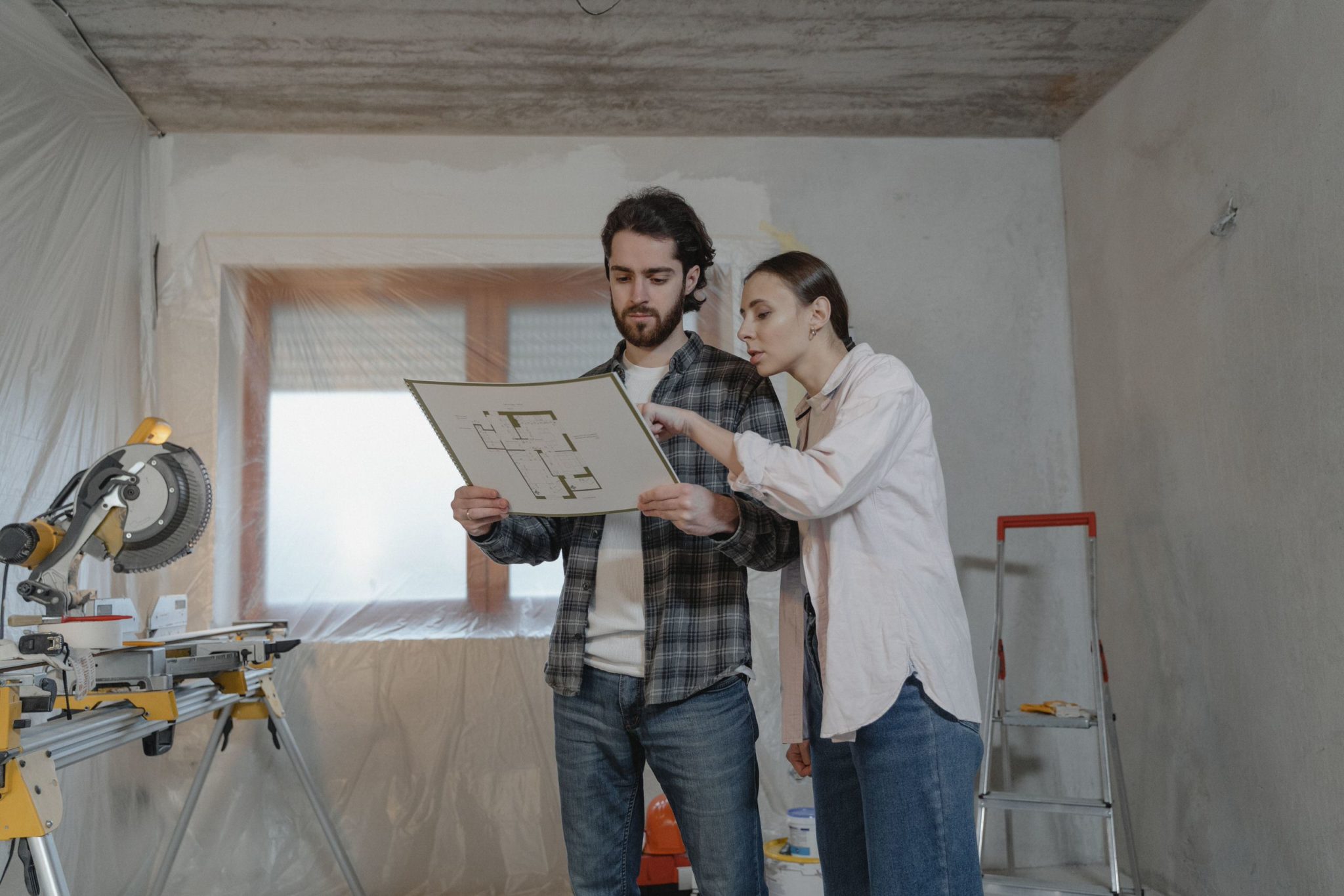 Couple consultant le plan de leur logement en cours de rénovation pour comprendre les recommandations de travaux de leur DPE