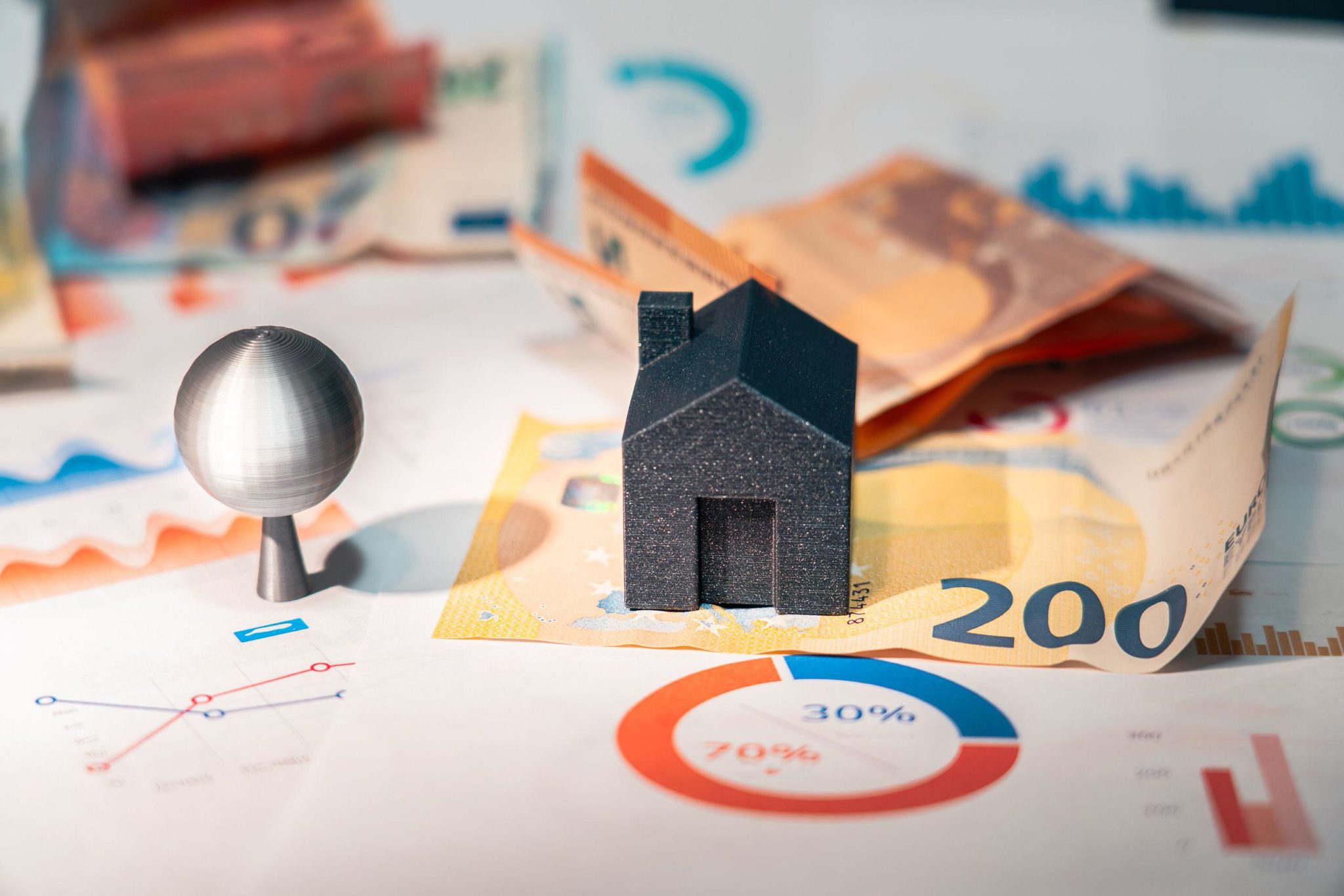 Maquette de maison posée sur des billets de 200 euros et des graphiques illustrant le coût d'un DPE en 2026