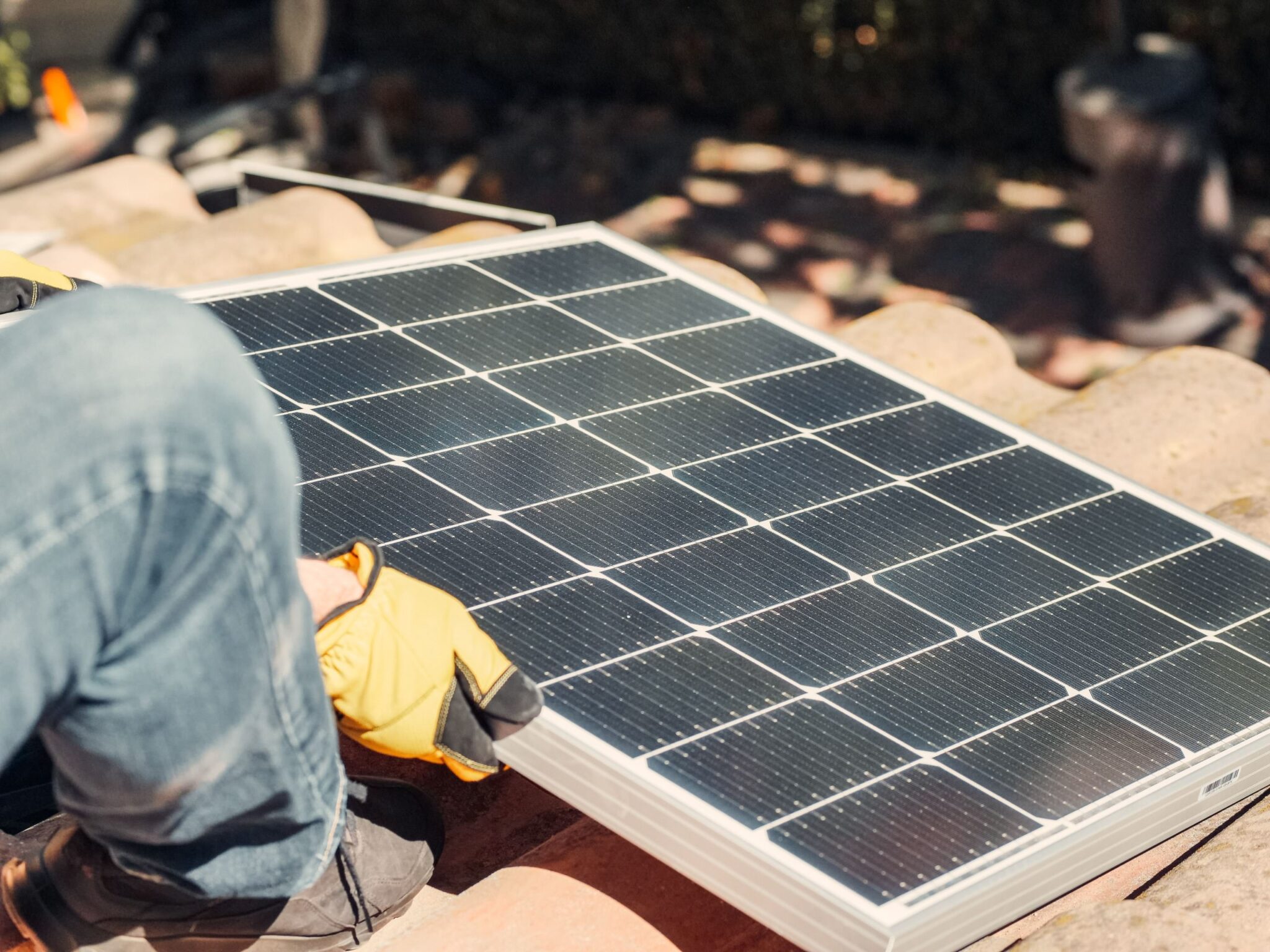 Rénovation énergétique : pose d'un panneau solaire photovoltaïque sur une toiture en tuiles